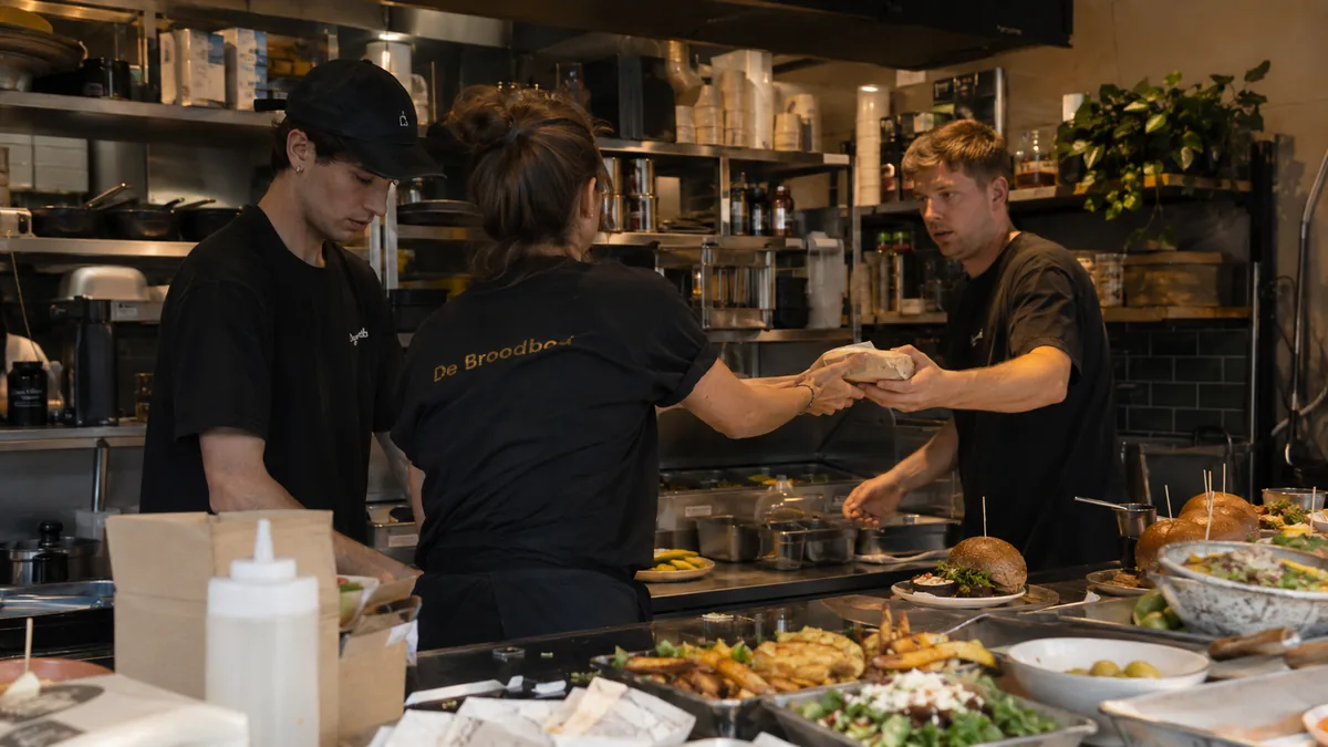 Staff at a coup partner handing off an order in the kitchen